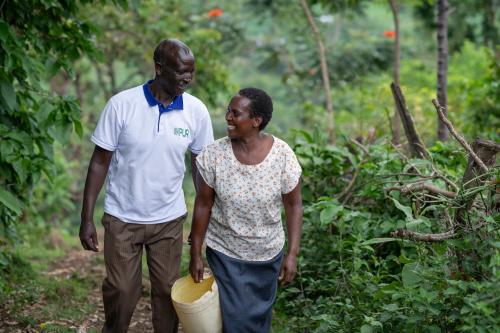 Two farmers walking in a coffee field